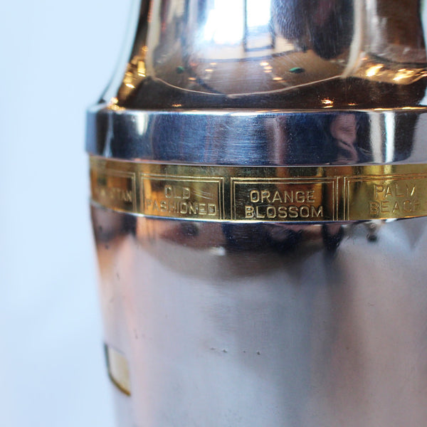 An Art Deco, silver plated and gilt recipe cocktail shaker. Integral strainer. Outer  sliver plated cover revealing brass underlayer with ingredients for various cocktails. Stamped 'Napier' to underside at Jeroen Markies.