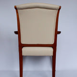 A pair of side chairs with walnut frames. Scrolled and carved detail to frames. Upholstered in cream leather. 