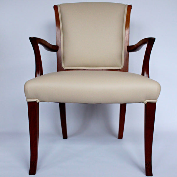 A pair of side chairs with walnut frames. Scrolled and carved detail to frames. Upholstered in cream leather. 
