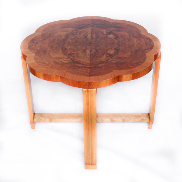 An Art Deco nest of tables in figured and straight grain walnut veneer. Main table with shaped edging set over cross footed base. Four shelved, integral side tables.