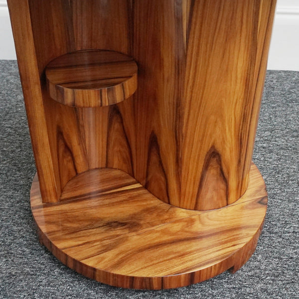 An Art Deco style centre table with a curved central column with hidden shelf to either side set over a circular base made from burr walnut veneer